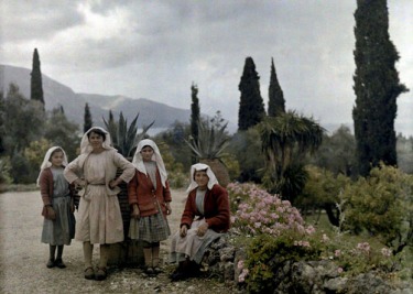 Γυναίκες και κορίτσια κάθονται στον κήπο ενός εξοχικού στους Αγίους Δέκα της Κέρκυρας.
